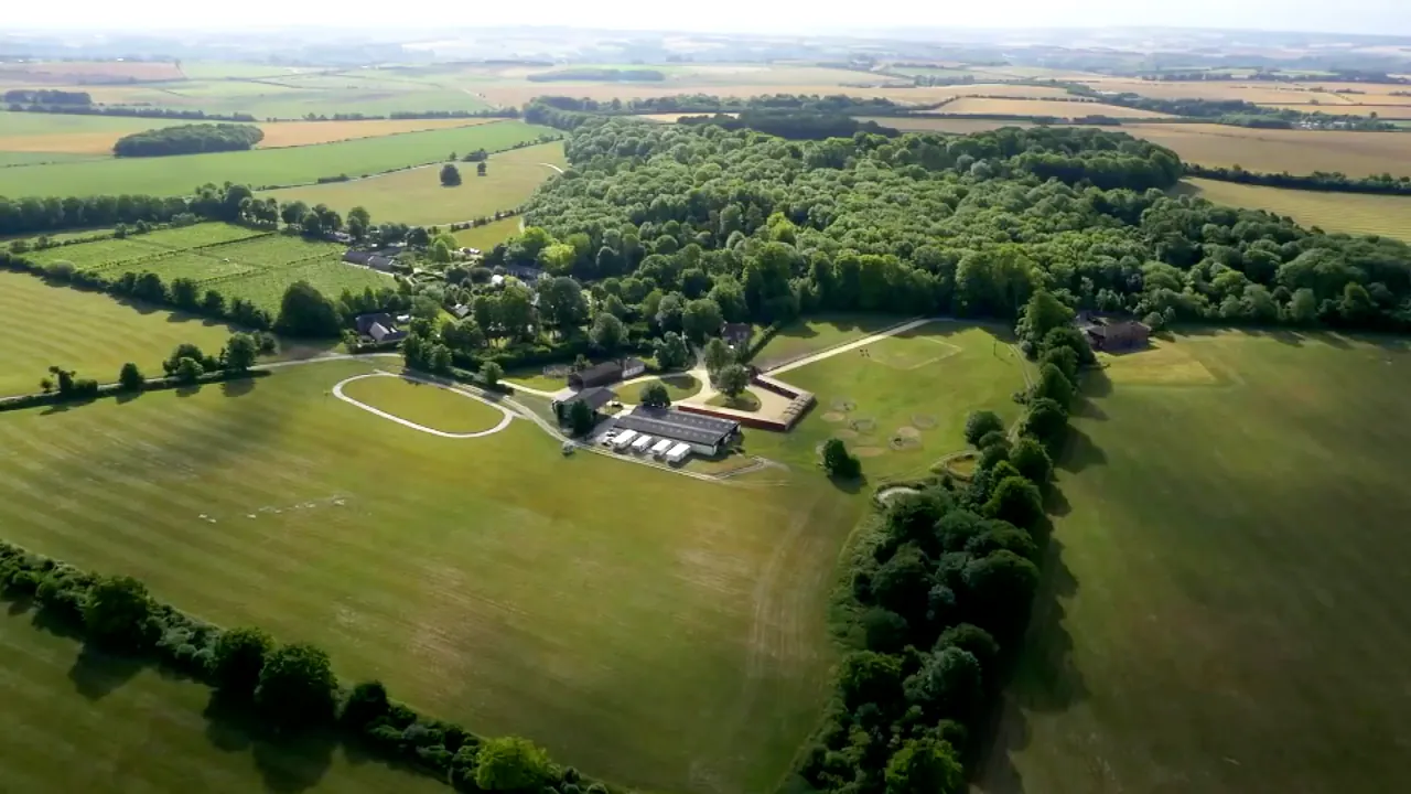 Aerial view of the Danebury estate: the stable yard among trees, surrounded by gallops and open downland
