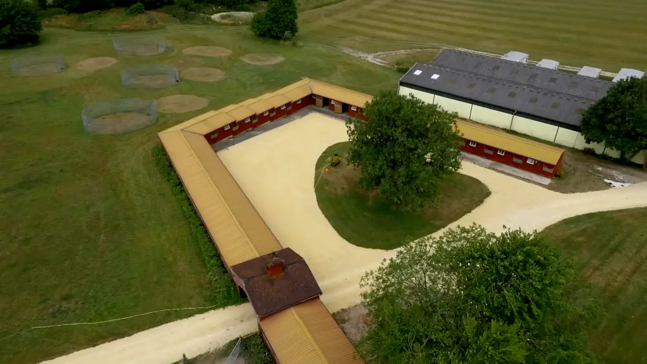 Aerial view of the timber courtyard yard, with horse walkers and paddocks beside it and one of the barns behind